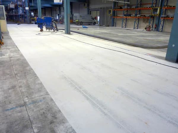 Allée de circulation en cours de grenaillage dans un atelier